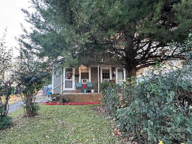 view of property hidden behind natural elements featuring a front yard