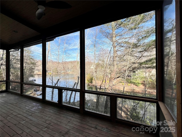 unfurnished sunroom with a water view and ceiling fan