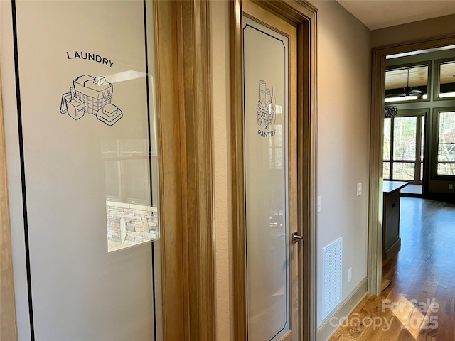 interior space featuring baseboards, visible vents, and wood finished floors