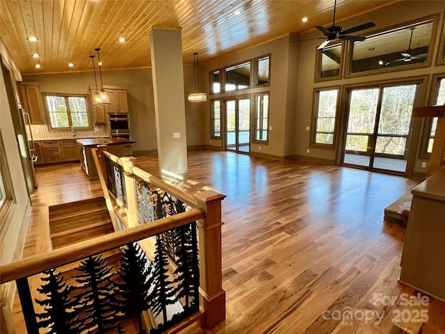 interior space featuring wood ceiling, light hardwood / wood-style flooring, high vaulted ceiling, and ceiling fan