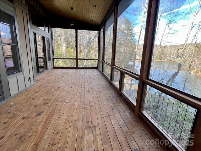 unfurnished sunroom with vaulted ceiling, a water view, and wood ceiling