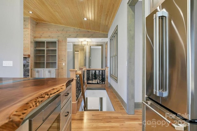 kitchen featuring lofted ceiling, wooden ceiling, high quality fridge, light wood-type flooring, and recessed lighting