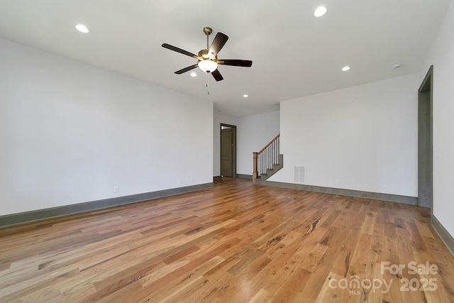 spare room featuring baseboards, visible vents, stairs, light wood-style floors, and recessed lighting