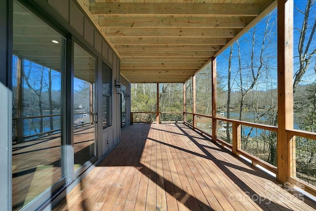 unfurnished sunroom with wooden ceiling and a water view