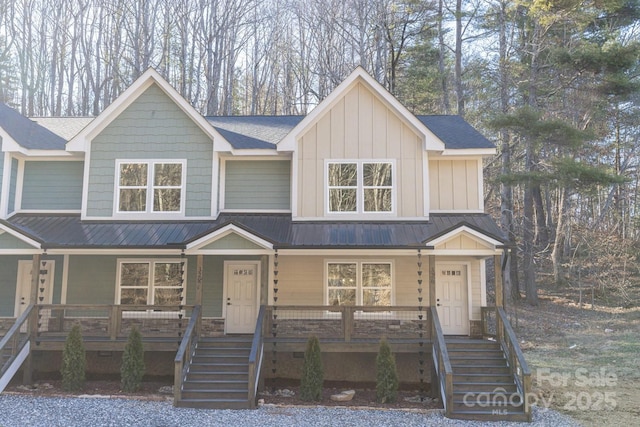 view of front of property featuring board and batten siding, covered porch, metal roof, and stairway