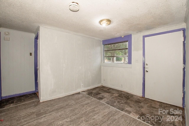 unfurnished room with a textured ceiling and hardwood / wood-style flooring