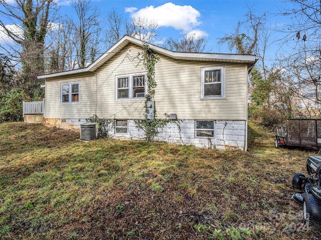 view of property exterior with a lawn and central AC unit