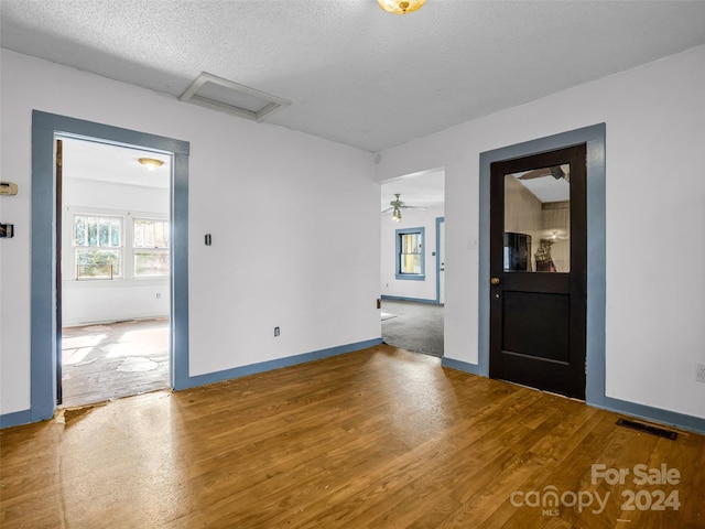 spare room featuring a textured ceiling, hardwood / wood-style flooring, and ceiling fan