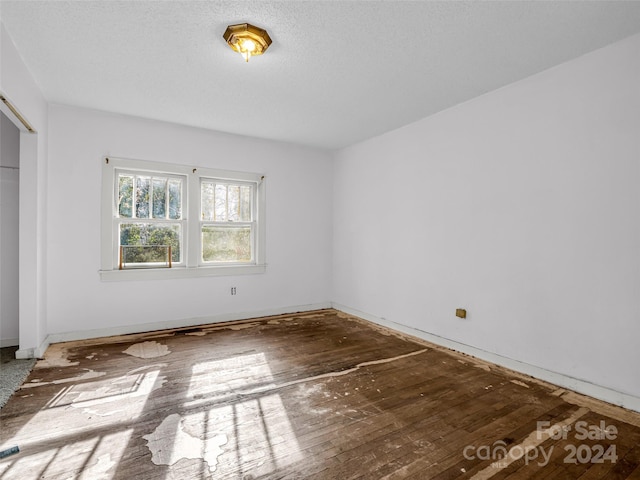 unfurnished bedroom with wood-type flooring and a textured ceiling