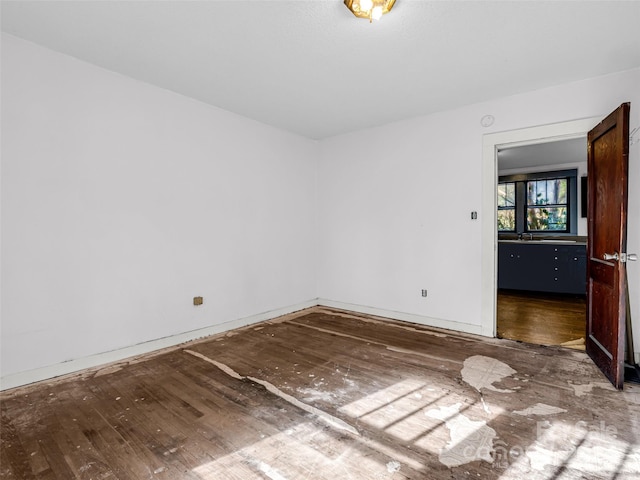 unfurnished room featuring wood-type flooring and sink