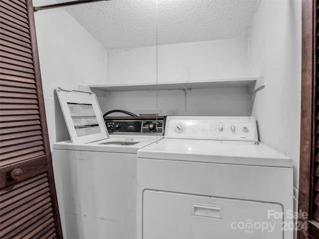 laundry room featuring independent washer and dryer and a textured ceiling