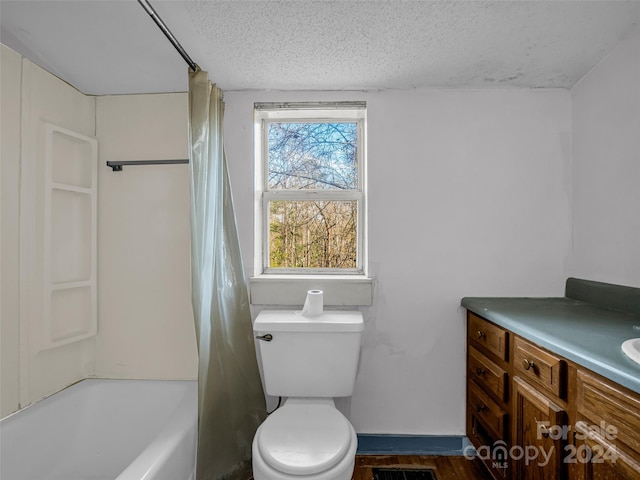 full bathroom with hardwood / wood-style floors, a textured ceiling, toilet, shower / bath combo with shower curtain, and vanity