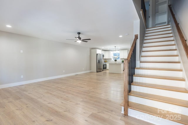 staircase with ceiling fan, baseboards, wood finished floors, and recessed lighting