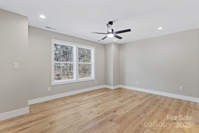 empty room featuring recessed lighting, baseboards, and light wood finished floors