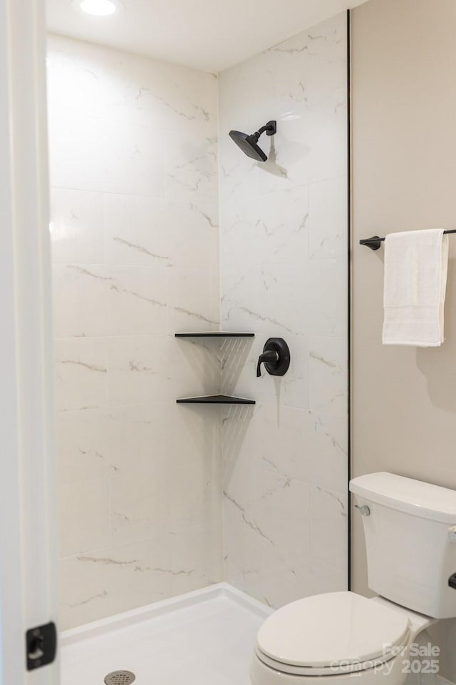 bathroom featuring a stall shower and toilet