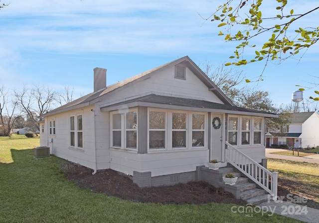 view of front facade featuring a front yard and central AC