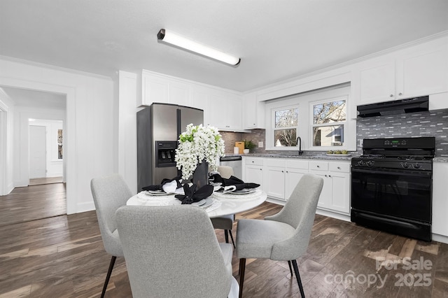 dining room with dark wood-type flooring, ornamental molding, and sink