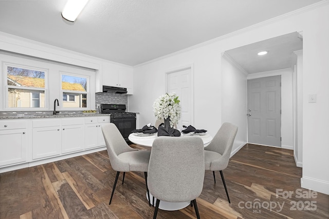 dining room with crown molding, dark hardwood / wood-style floors, and sink