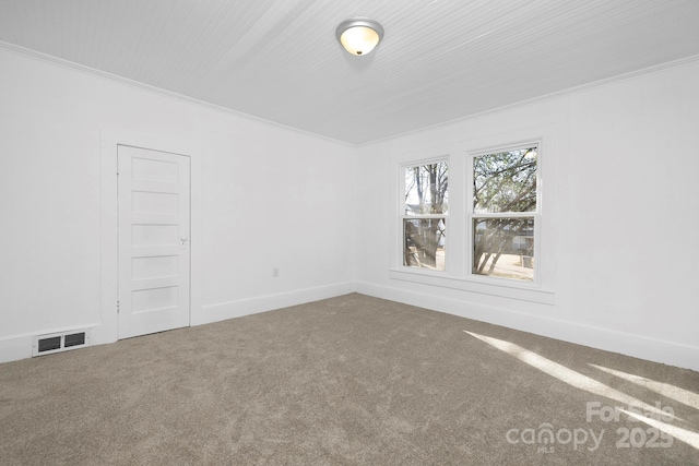 empty room featuring crown molding and carpet floors