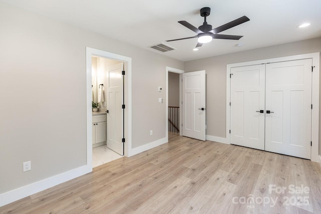 unfurnished bedroom with connected bathroom, visible vents, baseboards, light wood-style floors, and a closet