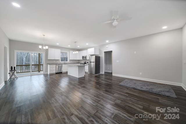 kitchen with a center island, dark wood-type flooring, appliances with stainless steel finishes, decorative light fixtures, and white cabinetry