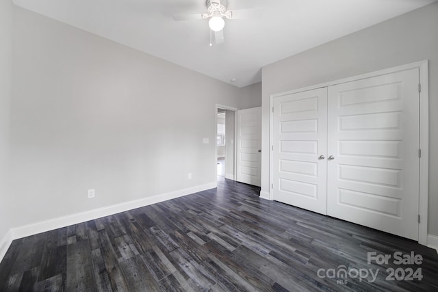 unfurnished bedroom featuring dark hardwood / wood-style flooring, a closet, and ceiling fan