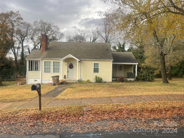 view of front of property with central AC and a front yard