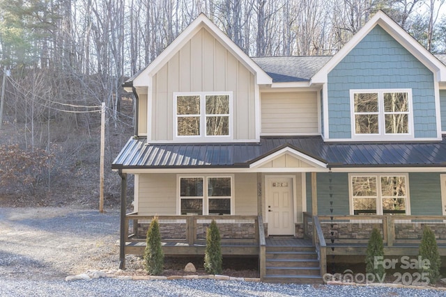 view of front of property featuring a porch, metal roof, driveway, and board and batten siding