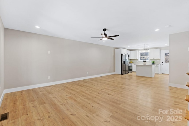 unfurnished living room with light wood-style flooring, visible vents, baseboards, and recessed lighting