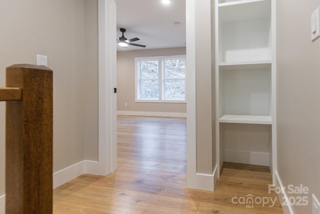 corridor with built in features, baseboards, and wood finished floors