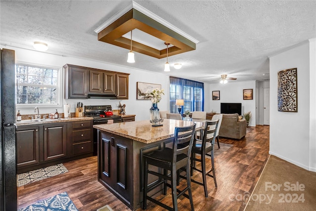 kitchen with electric range, a center island, sink, dark hardwood / wood-style flooring, and a kitchen bar