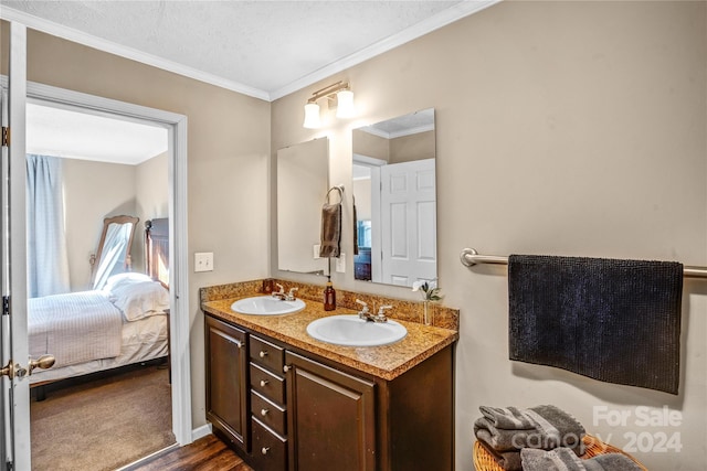 bathroom featuring vanity, wood-type flooring, a textured ceiling, and crown molding