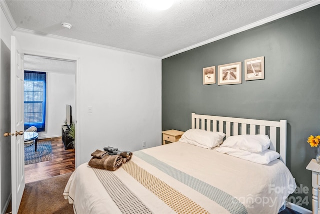 bedroom featuring a textured ceiling, crown molding, and dark wood-type flooring