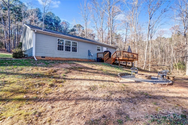 rear view of house featuring an outdoor fire pit and a wooden deck