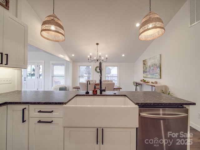 kitchen with white cabinets, dishwasher, lofted ceiling, and sink