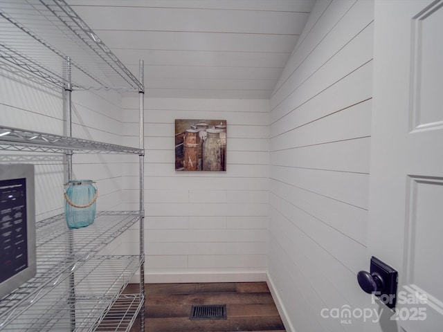 walk in closet featuring dark hardwood / wood-style flooring and vaulted ceiling