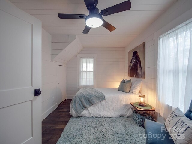 bedroom with ceiling fan, dark wood-type flooring, and vaulted ceiling