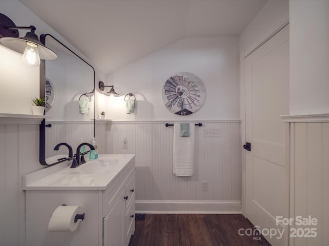 bathroom with vanity, vaulted ceiling, and hardwood / wood-style flooring