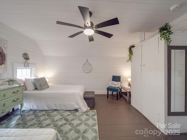 bedroom with dark hardwood / wood-style flooring, vaulted ceiling, and ceiling fan