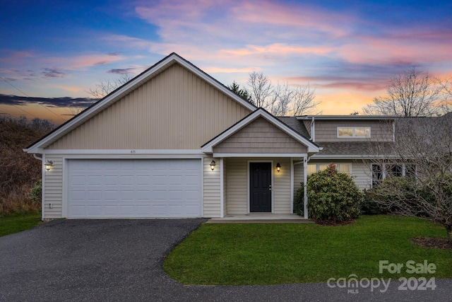 view of front of property with a garage and a lawn