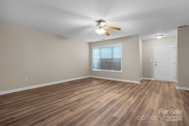 spare room with ceiling fan and dark wood-type flooring