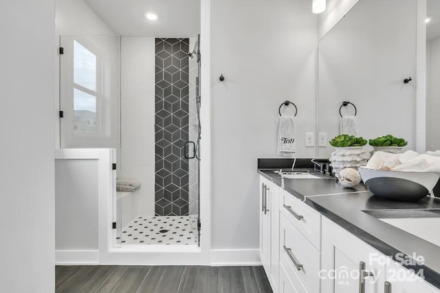 bathroom with vanity, wood-type flooring, and a shower with shower door