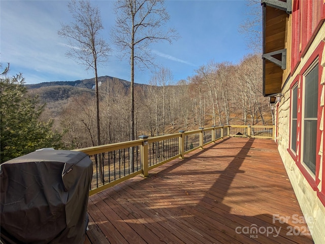 wooden deck featuring a wooded view and area for grilling