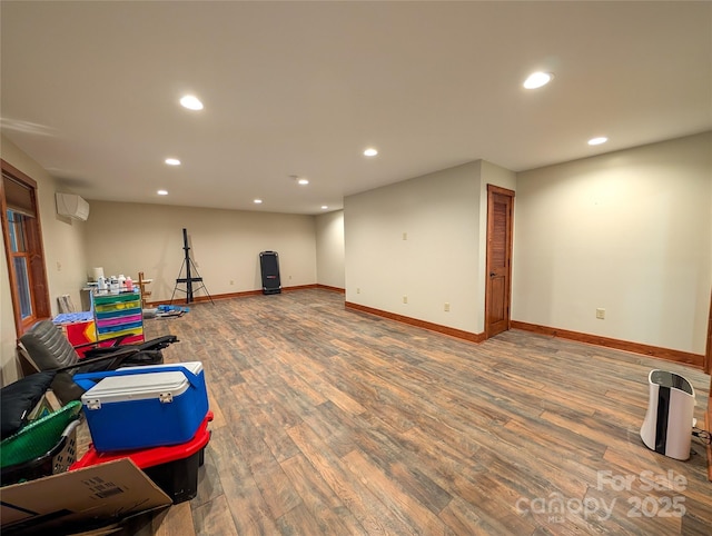 game room with a wall unit AC, wood finished floors, and recessed lighting