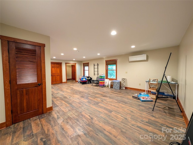 rec room with baseboards, a wall mounted air conditioner, wood finished floors, and recessed lighting