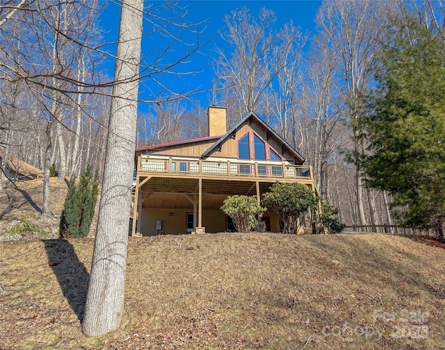 view of front of home featuring a chimney and a wooden deck