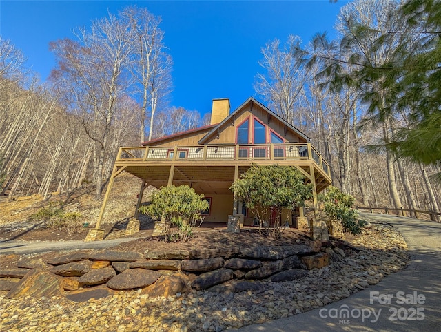 view of front of house featuring a chimney and a wooden deck