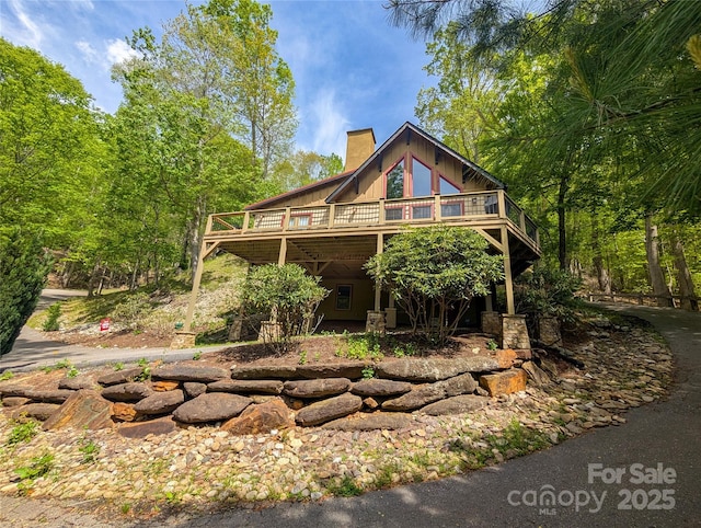 view of front of house featuring a chimney and a deck