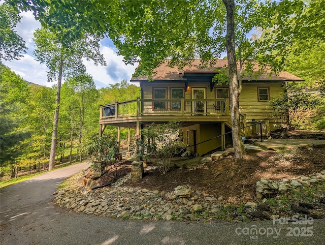 view of front of property featuring a wooden deck and aphalt driveway