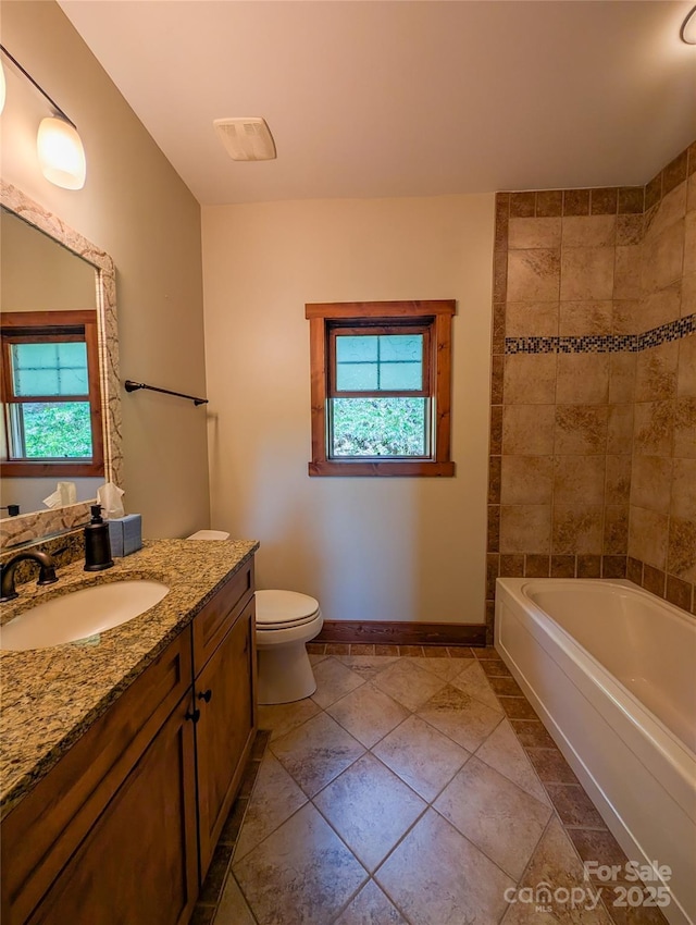 full bathroom with vanity, baseboards, toilet, and a wealth of natural light